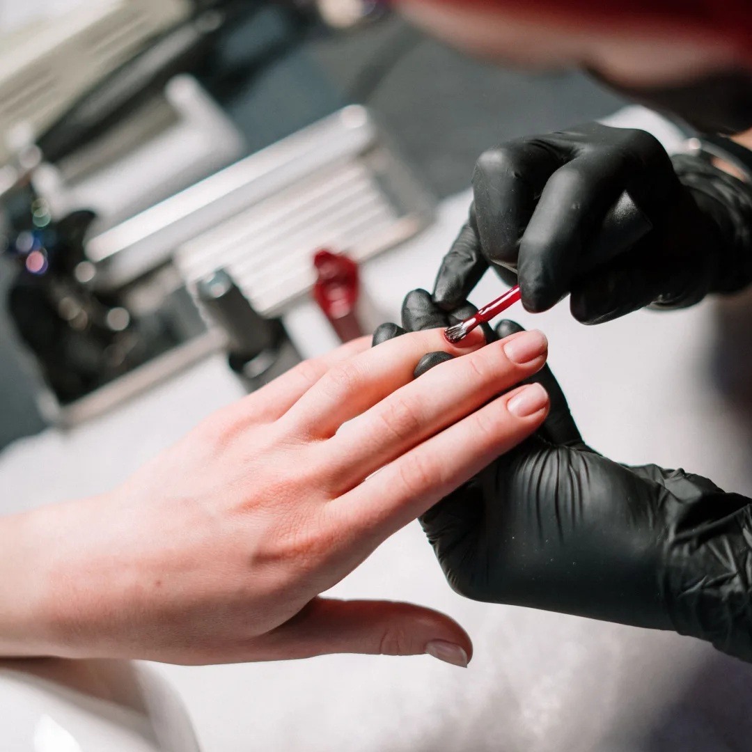 Nail artist applying gel polish in a stylish salon setting.